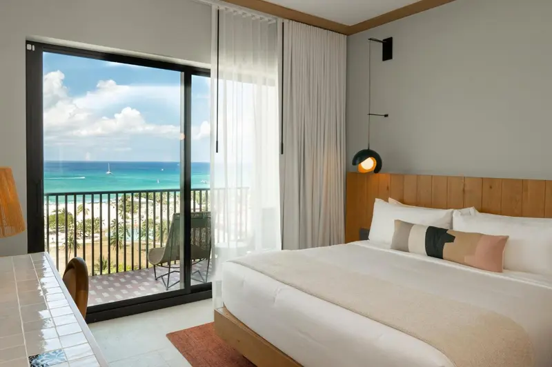 Une chambre lumineuse avec un grand lit et une vue sur la mer.