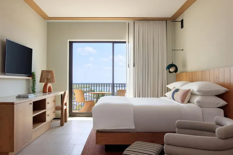 Chambre lumineuse avec un lit confortable et vue sur l'extérieur.