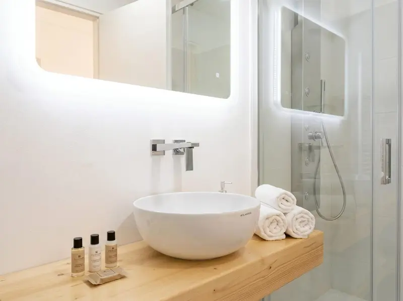 Une salle de bain moderne avec une douche à l'italienne et un lavabo sur un meuble en bois.