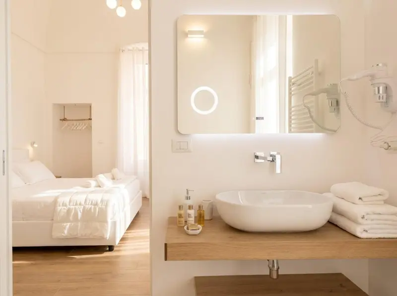 Une chambre lumineuse avec un lit et un lavabo moderne.