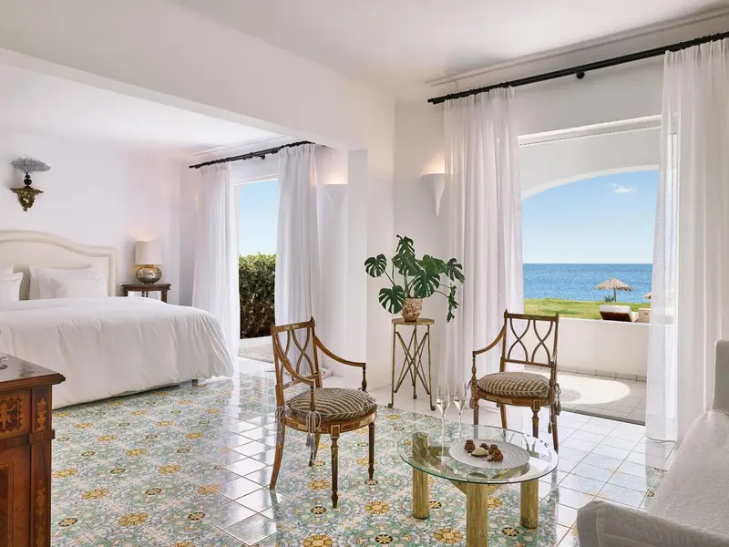Chambre lumineuse avec vue sur la mer depuis une terrasse.