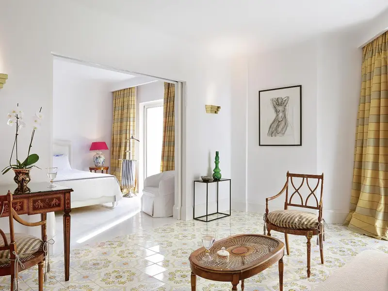 Une chambre lumineuse avec un lit et un coin salon.