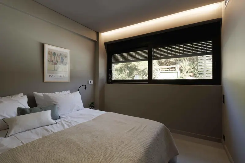 Une chambre lumineuse avec un grand lit et une fenêtre.