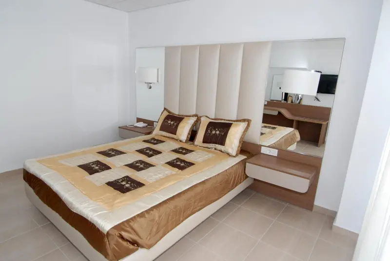 Une chambre lumineuse avec un grand lit et une décoration sobre.
