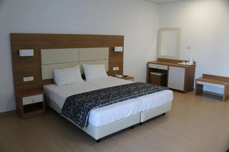 Une chambre lumineuse avec un grand lit et des tables de chevet.