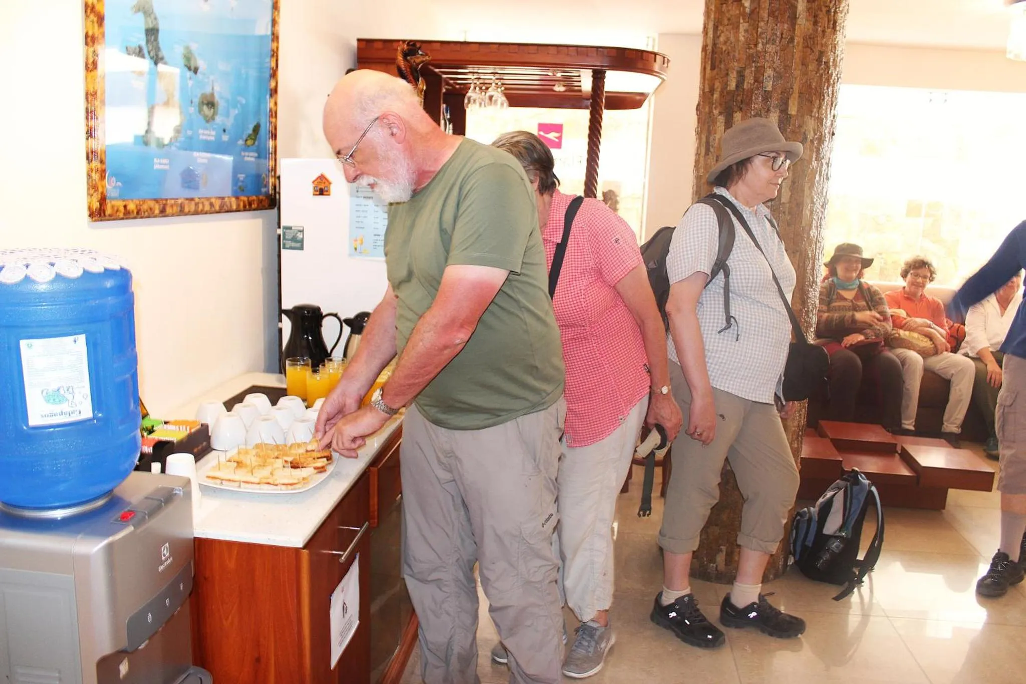 Des personnes se servent des viennoiseries et des boissons sur un comptoir.
