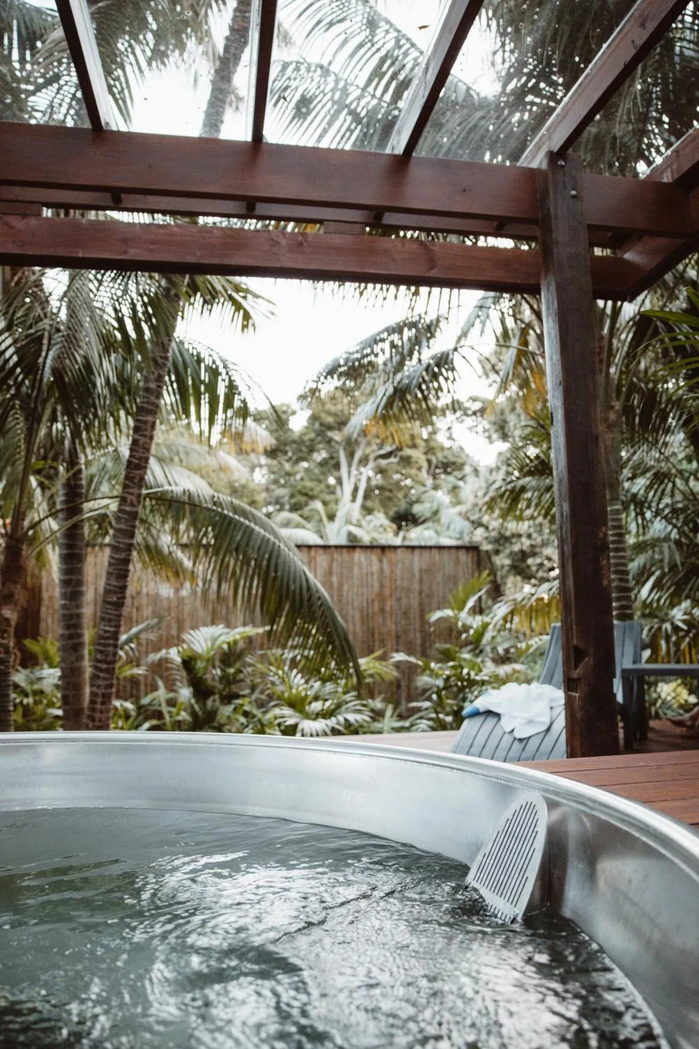 Une piscine extérieure en métal entourée de végétation tropicale.