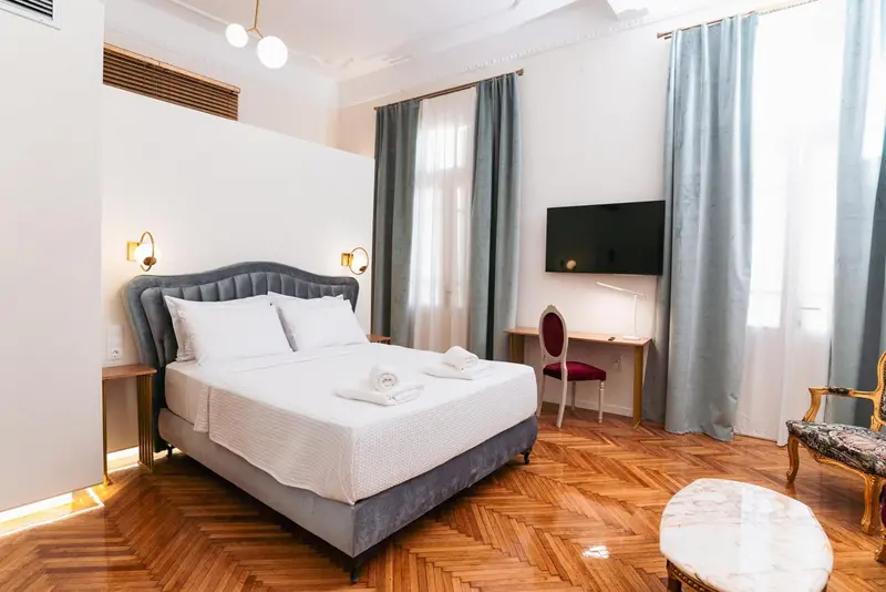 Une chambre lumineuse avec un grand lit et un bureau.