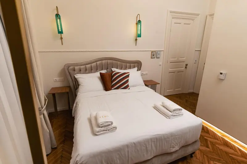 Une chambre avec un grand lit recouvert d'une courtepointe et d'oreillers.