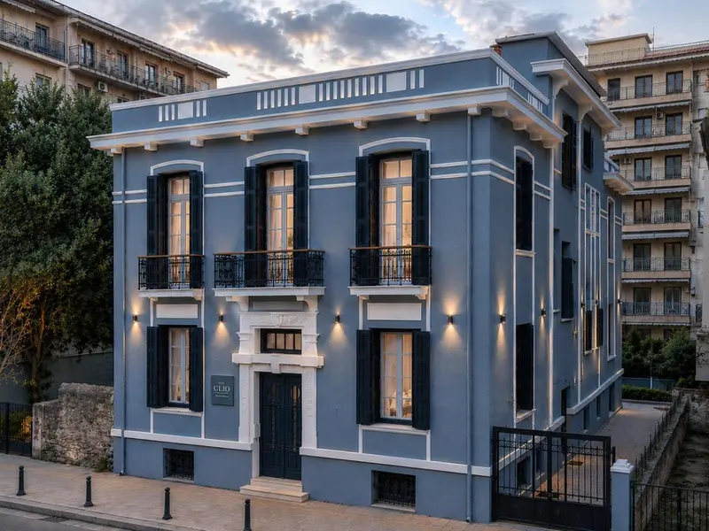Facade d'un bâtiment bleu à deux étages avec des volets fermés.