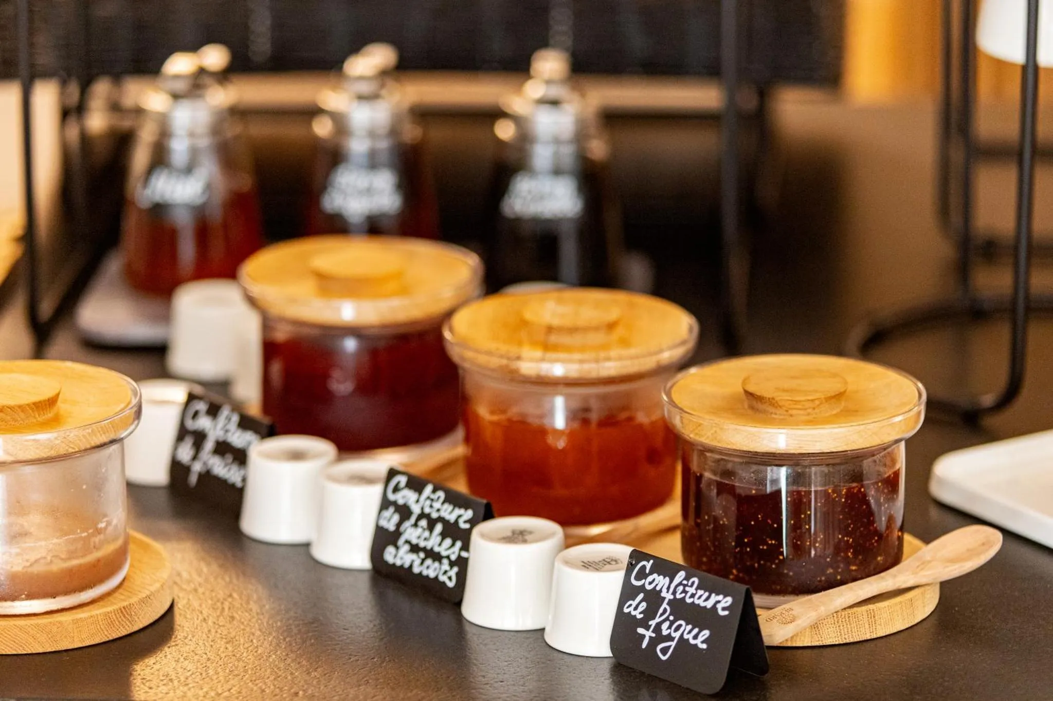 Des pots de confiture variés sont présentés sur un buffet.