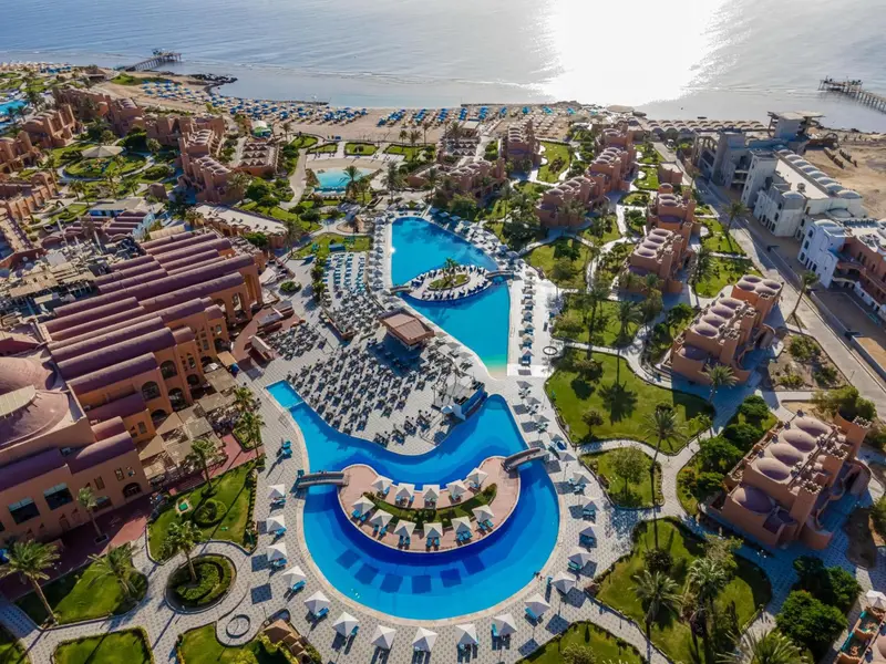 Vue aérienne d'un complexe hôtelier avec des piscines et des bâtiments bas.