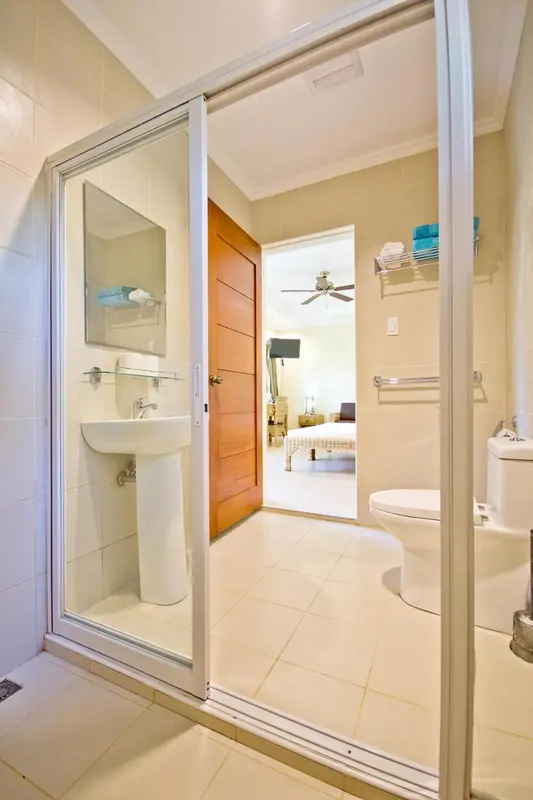 Une salle de bain claire avec douche à l'italienne et lavabo.
