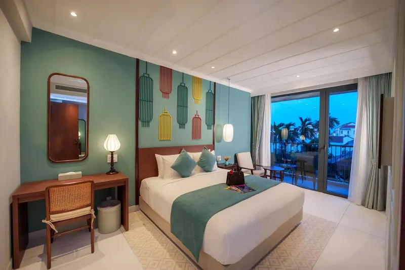 Une chambre lumineuse avec un grand lit et un accès à un balcon.
