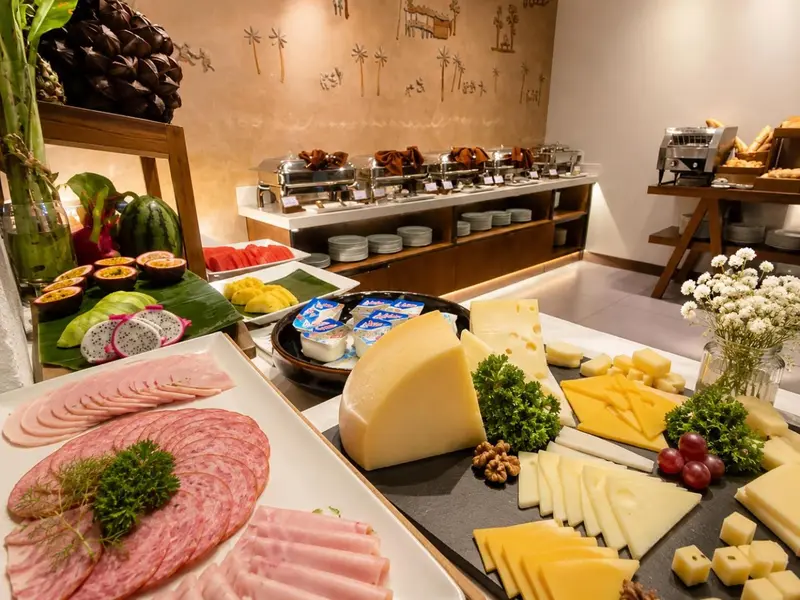 Un buffet propose une variété de charcuteries, de fromages et de fruits frais.