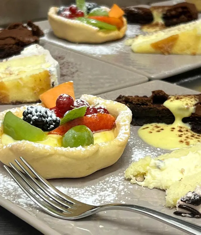 Assortiment de pâtisseries et de fruits frais présentés sur une table.