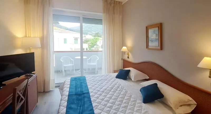 Une chambre lumineuse avec un lit et un accès à une terrasse.