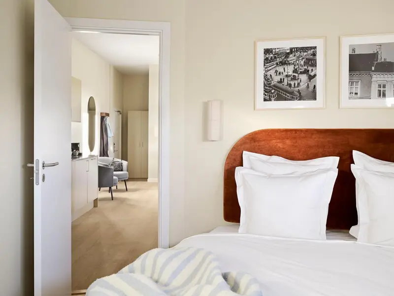 Une chambre à coucher avec un lit recouvert d'une courtepointe et un tableau au mur.