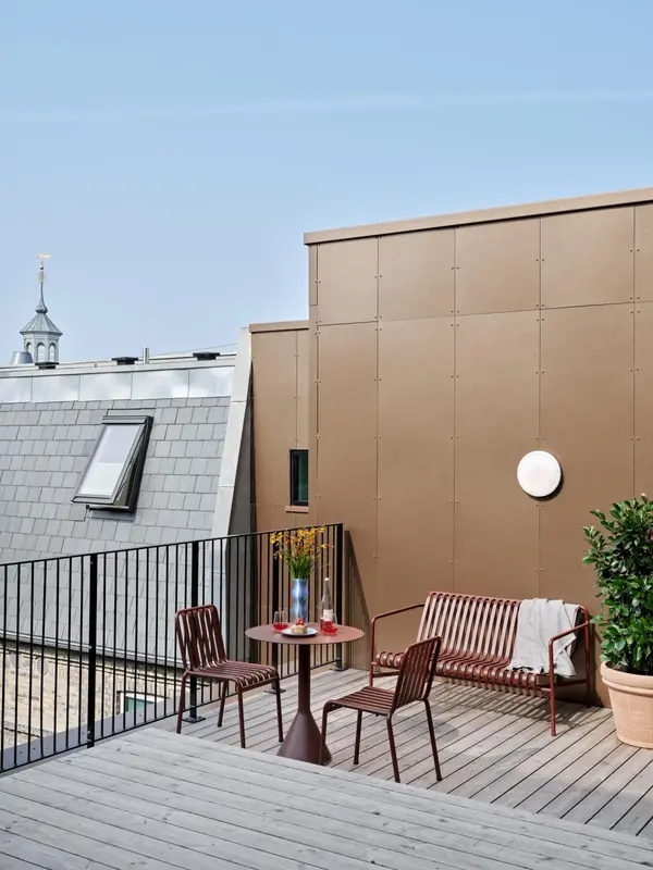 Terrasse aménagée avec mobilier de jardin et vue sur les toits.