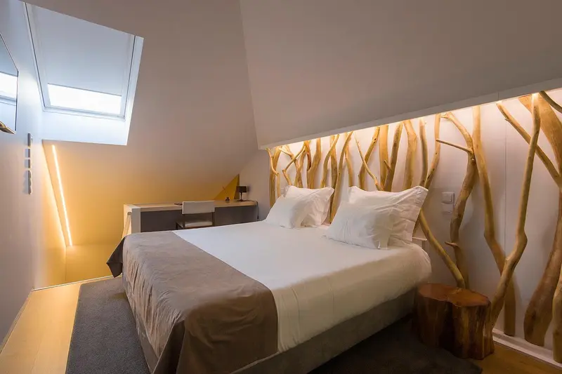 Une chambre lumineuse avec un grand lit et une décoration murale en bois.
