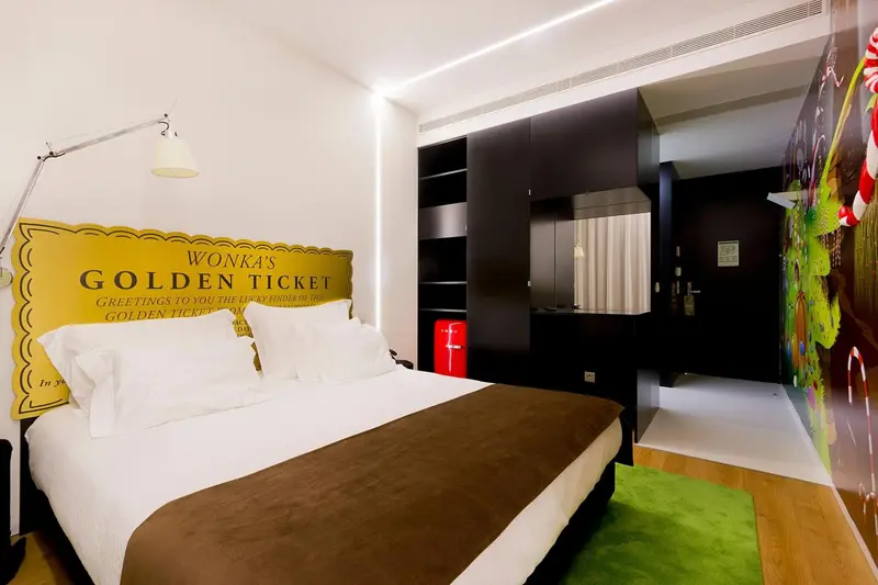 Une chambre avec un grand lit recouvert d'une couette blanche et de coussins.