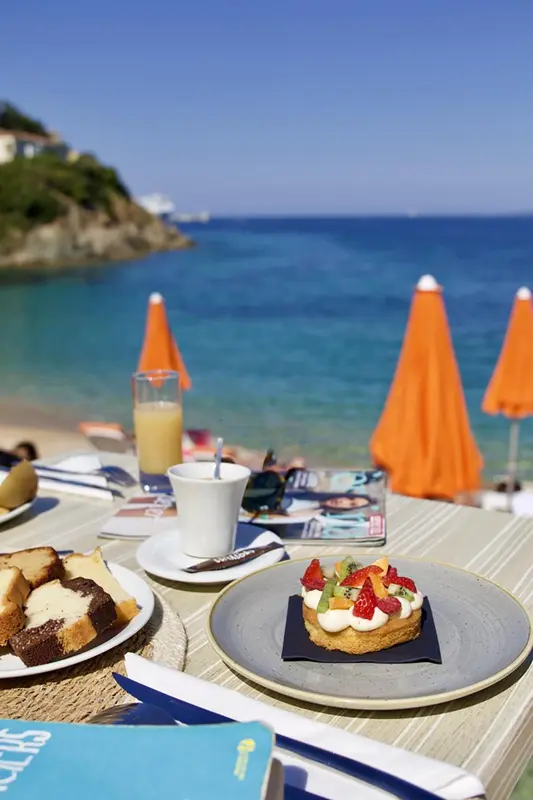 Une table de petit-déjeuner est dressée sur une plage ensoleillée.