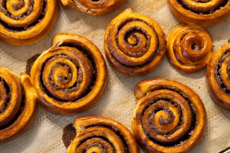 Des viennoiseries tourbillonnées dorées sont disposées sur une surface.