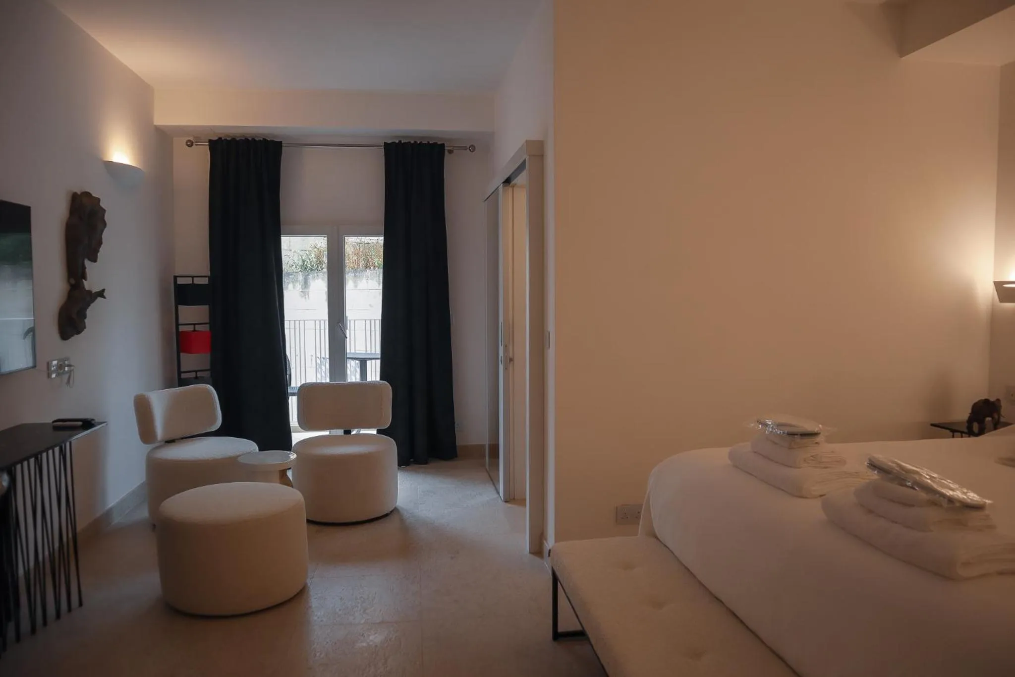 Espace de détente lumineux avec canapés blancs et accès à une terrasse.