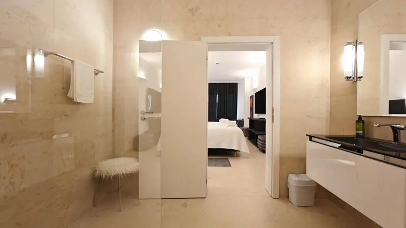 Une salle de bain lumineuse avec une douche à l'italienne et un meuble vasque moderne.