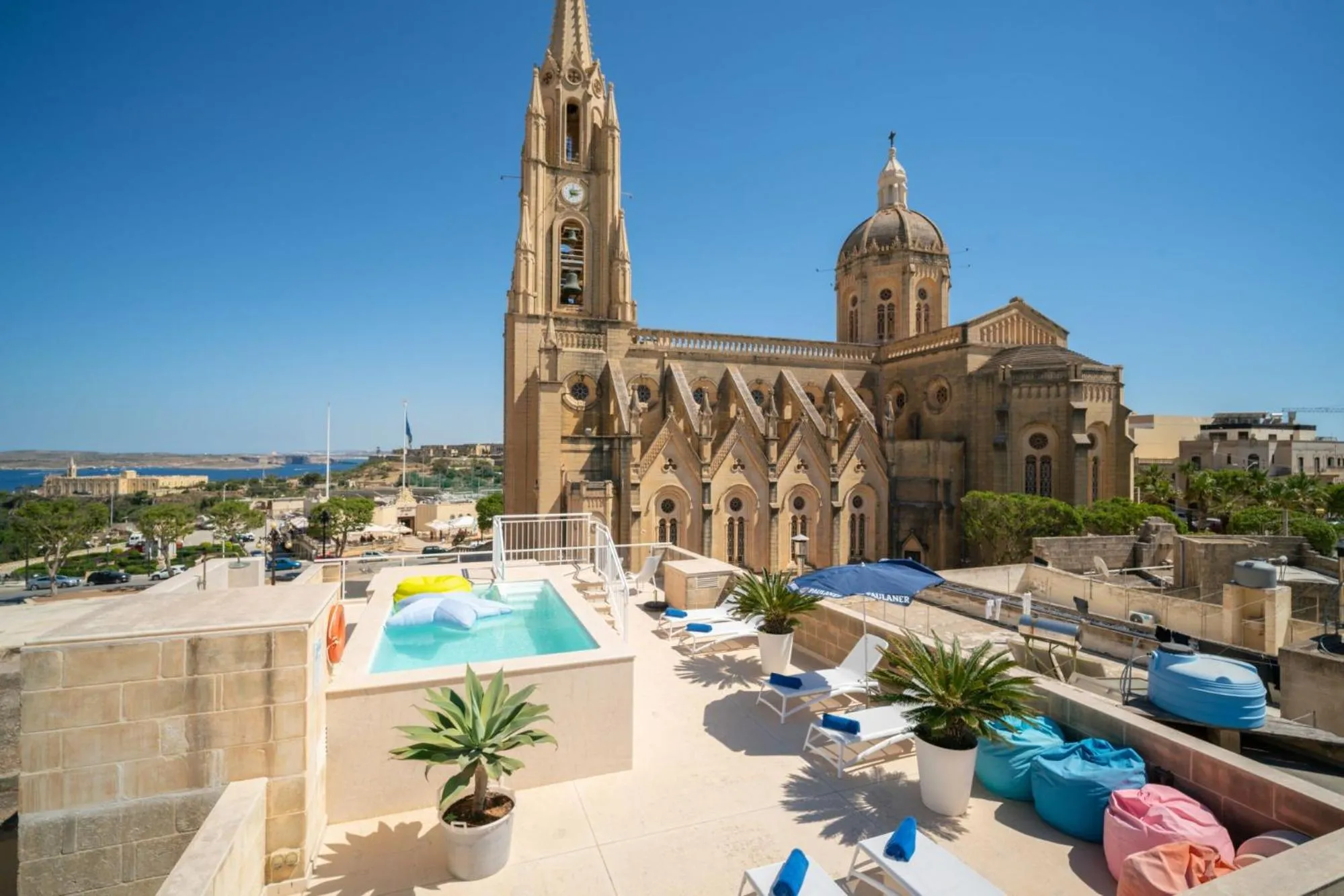 Terrasse avec piscine et vue sur des édifices religieux.