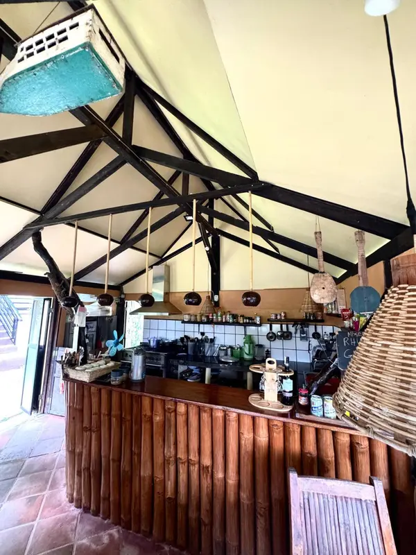 Un comptoir en bambou dans un espace ouvert avec une toiture en chaume.