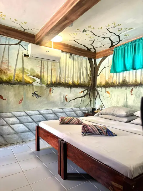 Une chambre lumineuse avec un lit simple et une décoration murale représentant un paysage aquatique.