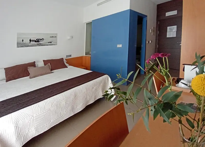 Une chambre lumineuse avec un grand lit et une décoration moderne.