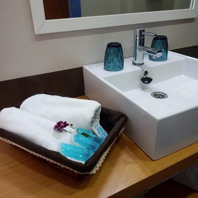 Un lavabo blanc avec des serviettes pliées et des articles de toilette.