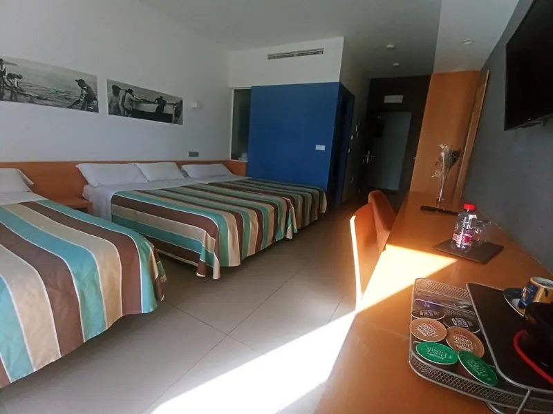 Une chambre lumineuse avec un grand lit et un bureau.