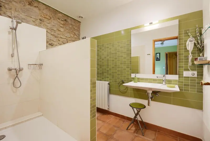 Une salle de bain lumineuse avec douche et lavabo.