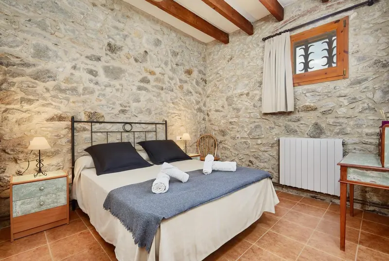 Une chambre à coucher avec un lit recouvert d'une couverture et d'oreillers.