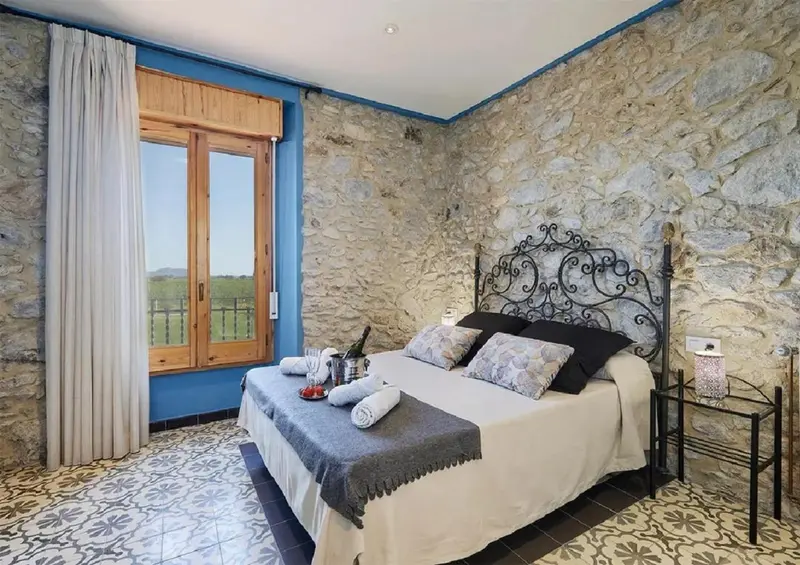 Une chambre à coucher lumineuse avec un lit décoré et une vue sur le paysage.
