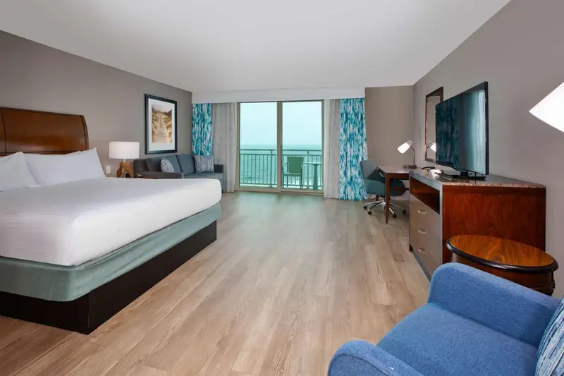 Une chambre lumineuse avec un grand lit et une vue sur la mer.