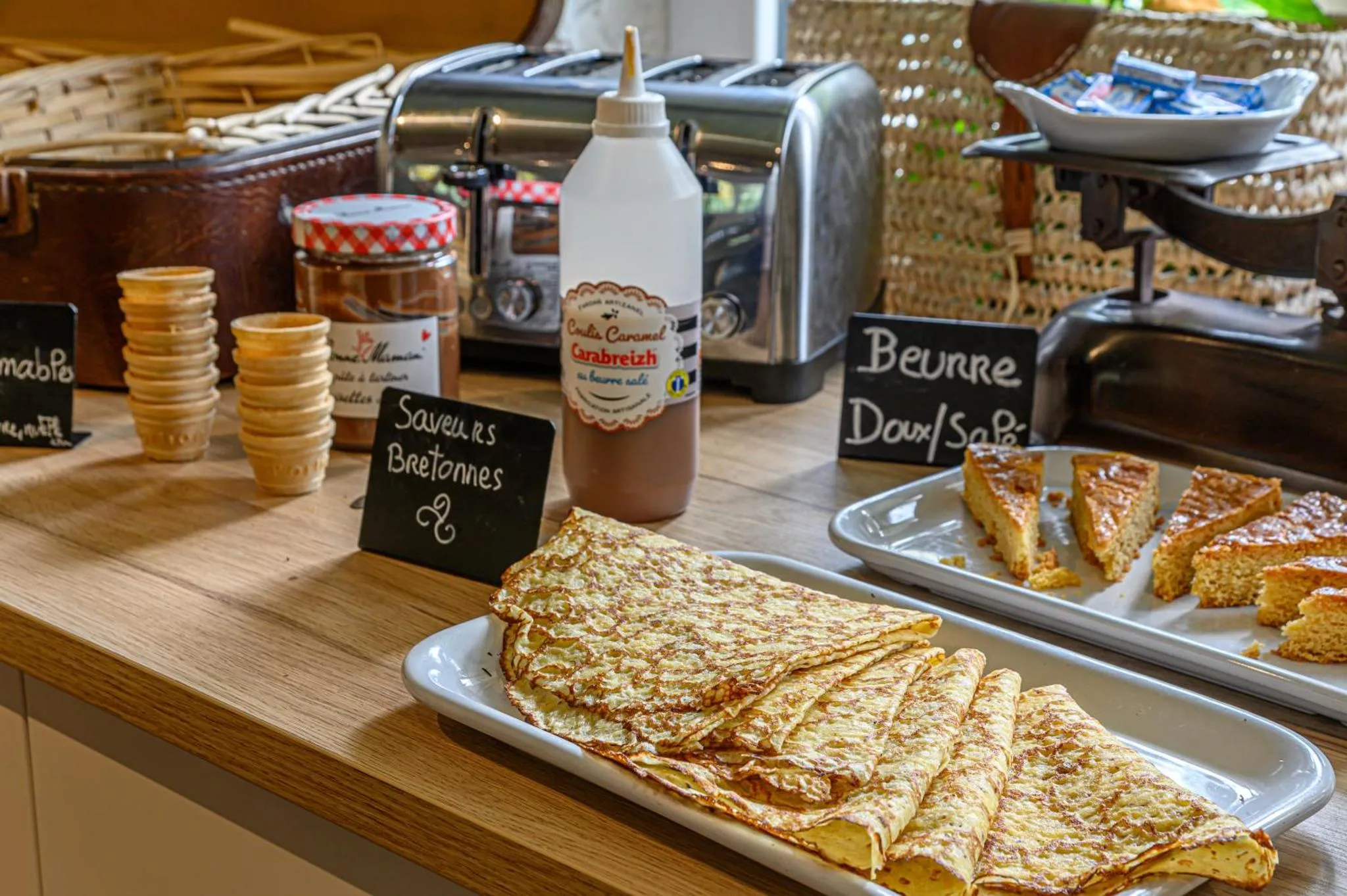 Un buffet propose des crêpes, de la confiture et du beurre.