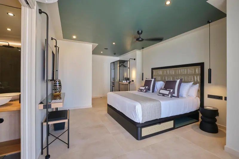 Une chambre lumineuse avec un grand lit et un coin salon.