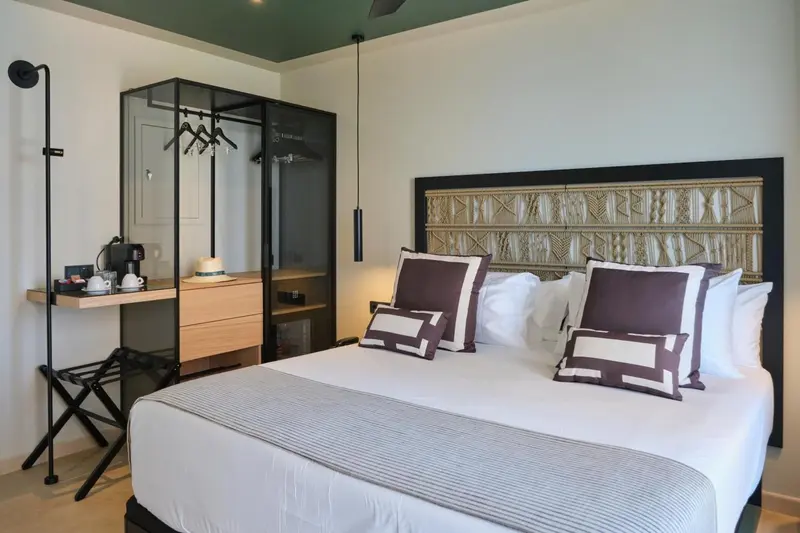 Une chambre lumineuse avec un grand lit et un espace détente.