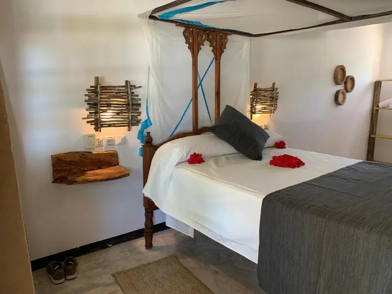 Lit recouvert de pétales de fleurs dans une chambre décorée.
