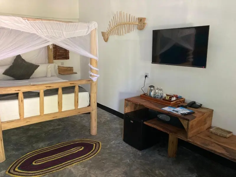 Une chambre lumineuse avec un lit à baldaquin et une décoration murale en forme de squelette de poisson.