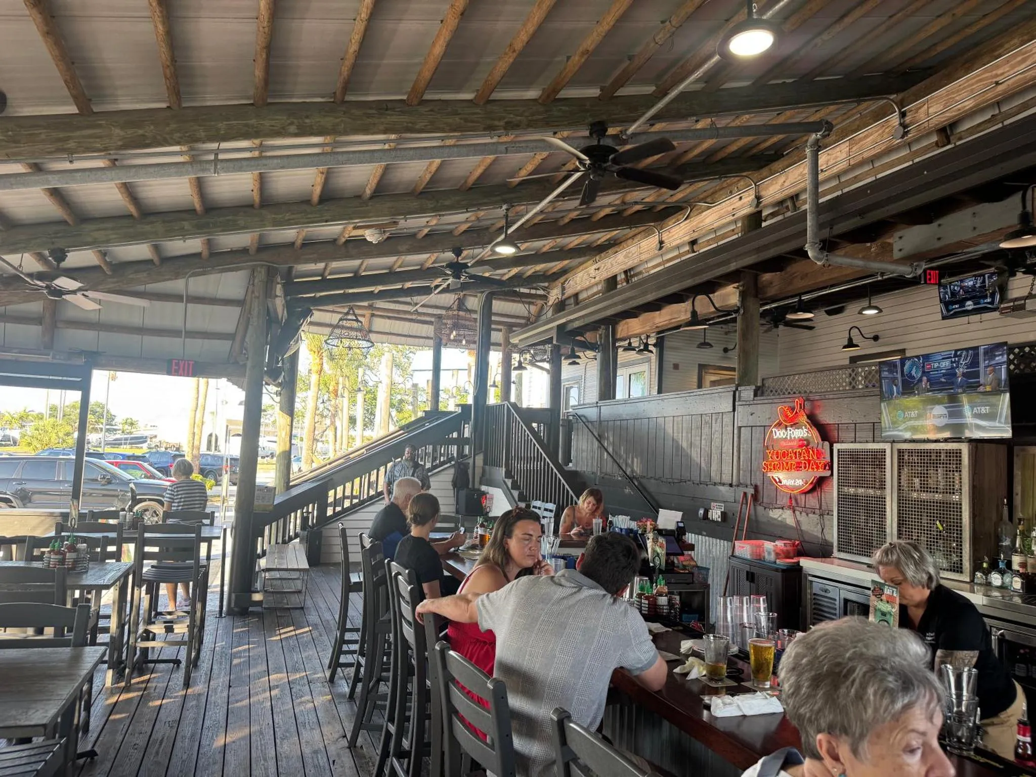 Une terrasse abritée avec des tables, des chaises et un comptoir de bar.