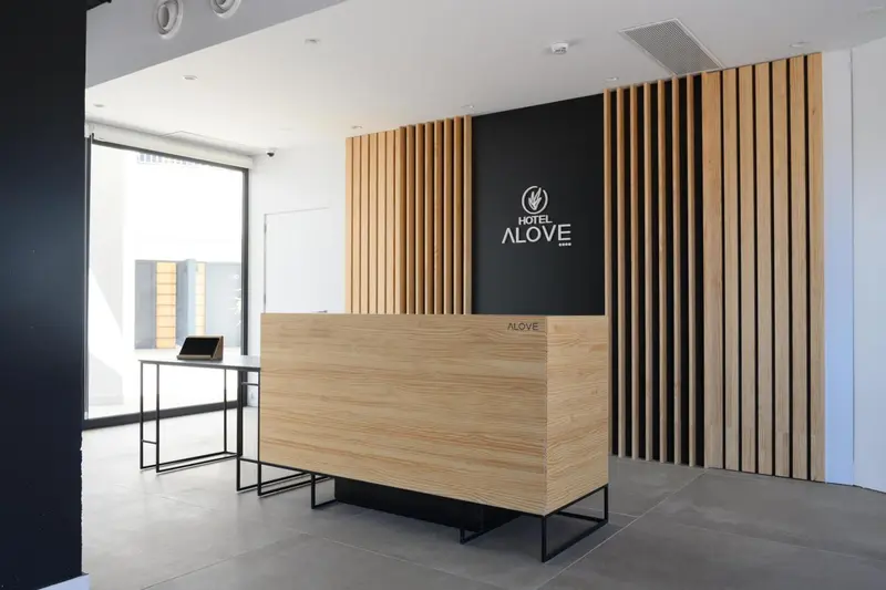 Un comptoir d'accueil moderne en bois clair dans un hall d'hôtel.
