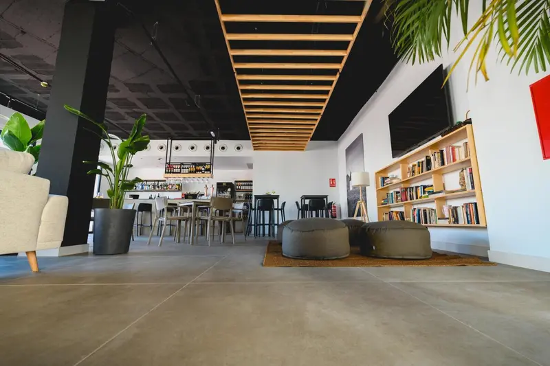 Espace intérieur lumineux avec mobilier confortable et bibliothèque.