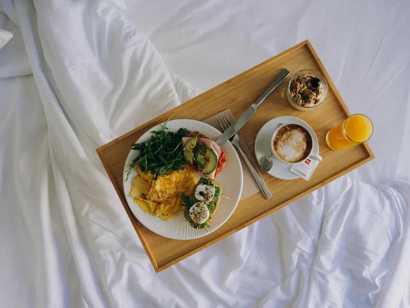 Petit déjeuner servi sur un plateau en bois au lit.