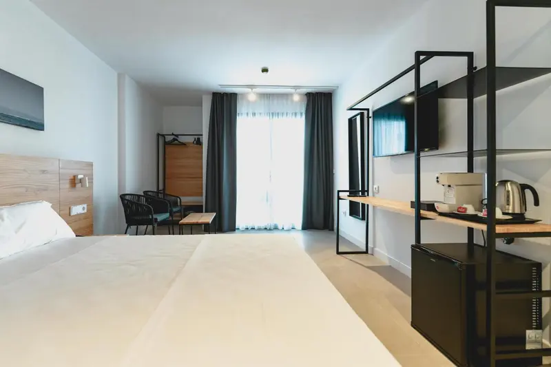 Chambre lumineuse avec un grand lit et un espace détente.
