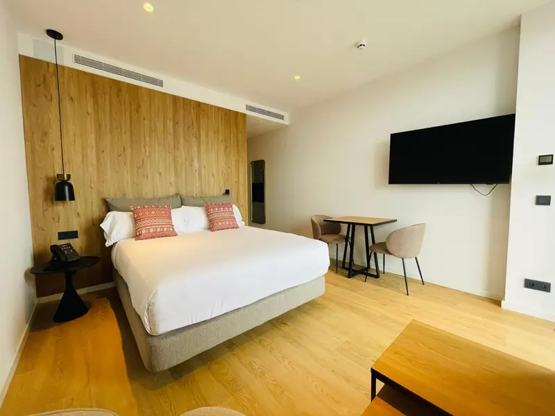 Une chambre lumineuse avec un grand lit et une table basse.